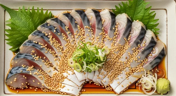Overhead view of authentic Japanese Goma Saba featuring glistening slices of fresh raw mackerel arranged in a fan pattern on...
