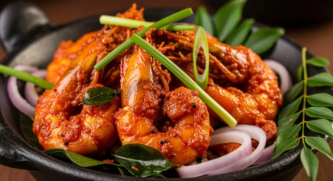 Close-up of authentic Sri Lankan Isso Devil featuring sizzling prawns coated in a vibrant red-orange spicy sauce, garnished...